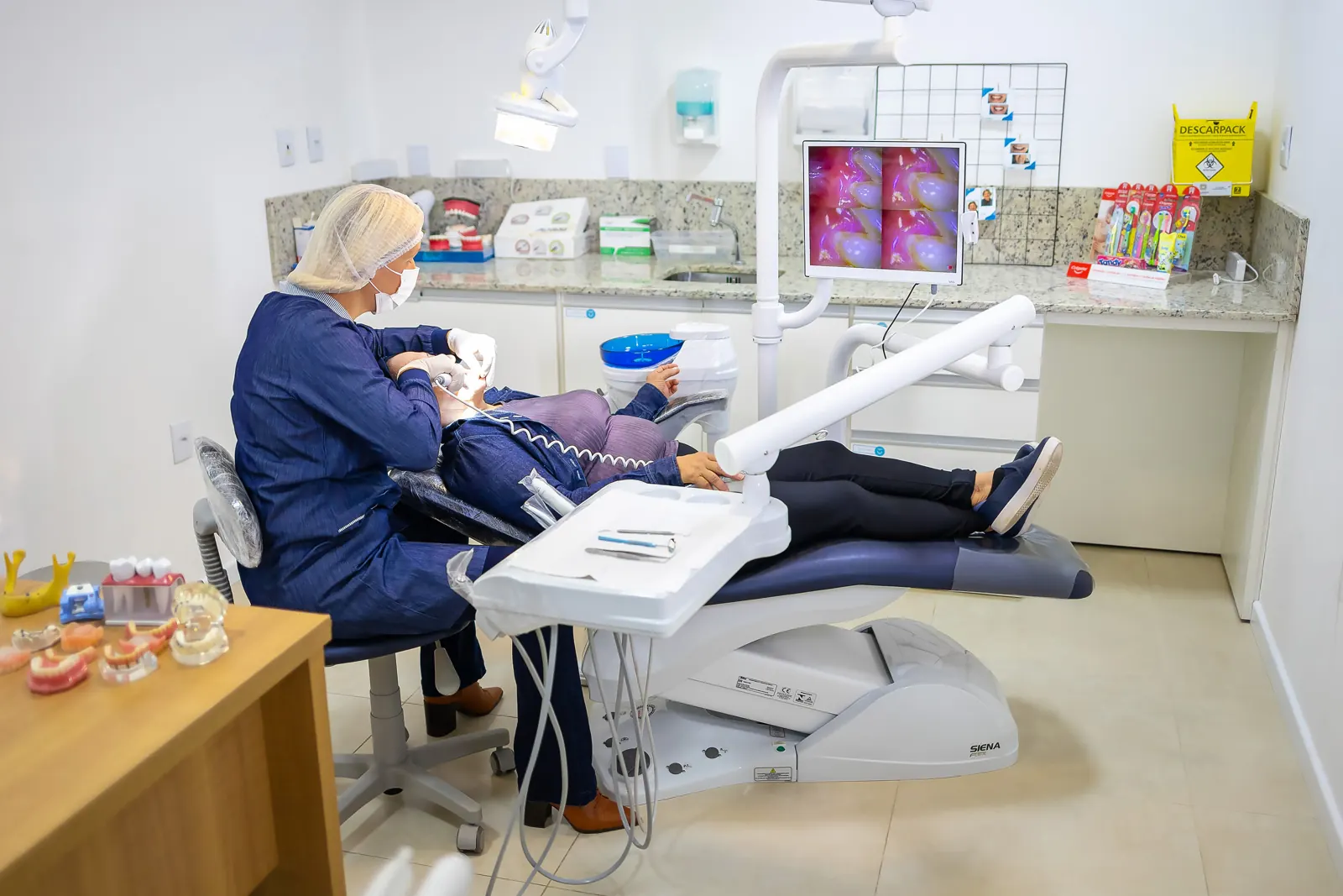 Consultório odontológico com paciente em atendimento
